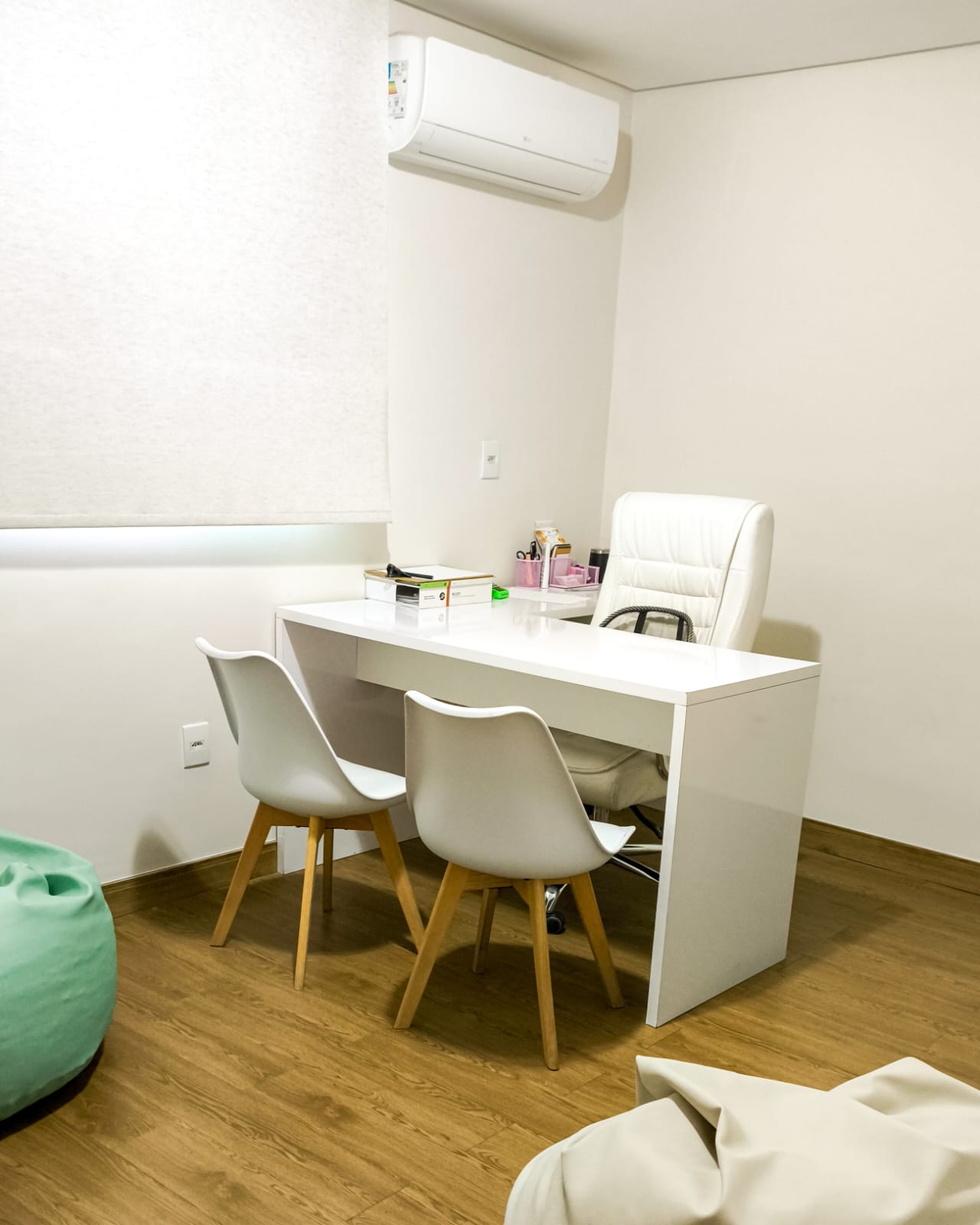 Consultório com mesa branca e cadeiras